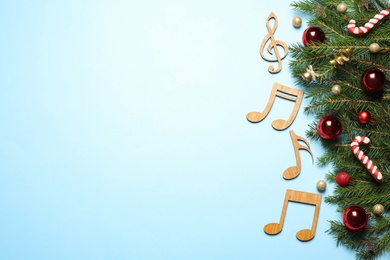 Photo of Flat lay composition with Christmas decor and music notes on light blue background, space for text