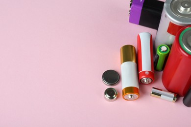 Image of Different types of batteries on pink background, closeup. Space for text