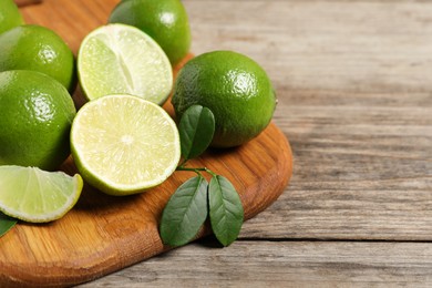 Fresh ripe limes on wooden table, closeup. Space for text