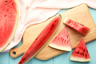 Photo of Yummy cut watermelon on light blue wooden table, flat lay