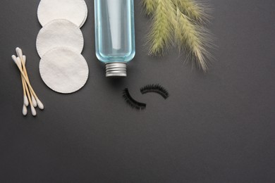 Photo of Flat lay composition with makeup removal tools, spikelets and false eyelashes on dark grey background. Space for text