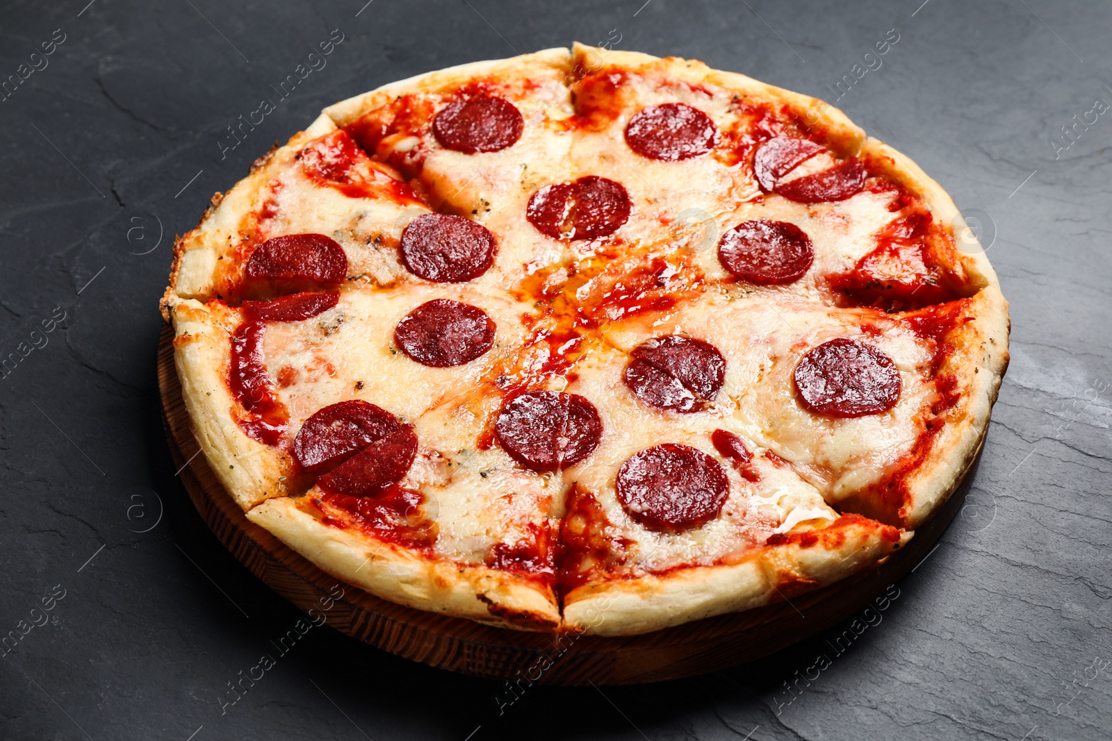 Photo of Hot delicious pepperoni pizza on dark table