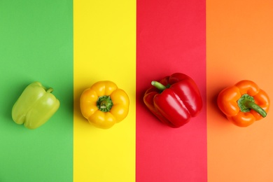 Flat lay composition with ripe bell peppers on color background