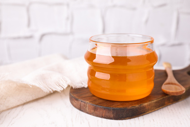 Photo of Tasty aromatic honey on white wooden table