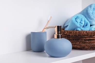 Stylish soap dispenser, holder with toothbrush and towels on shelf