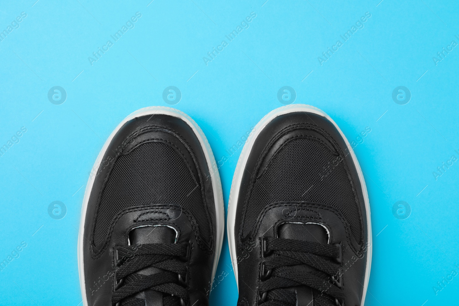 Photo of Pair of stylish shoes on blue background, top view