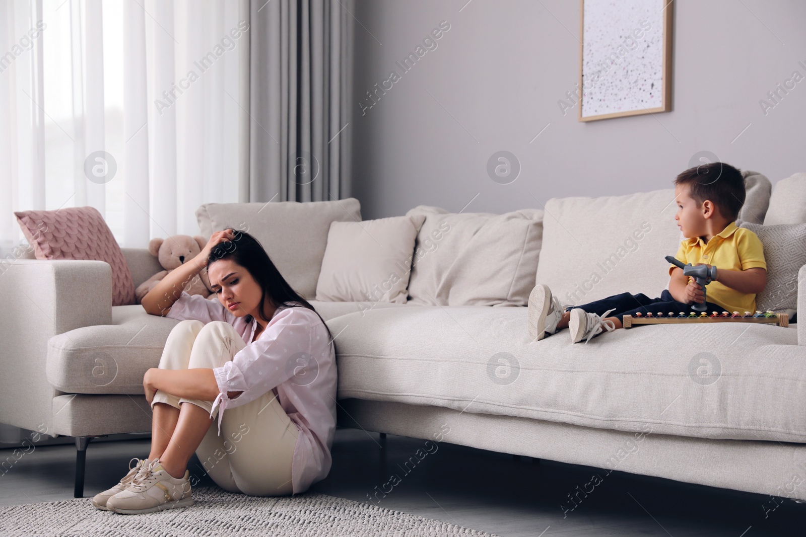 Photo of Depressed single mother with child in living room