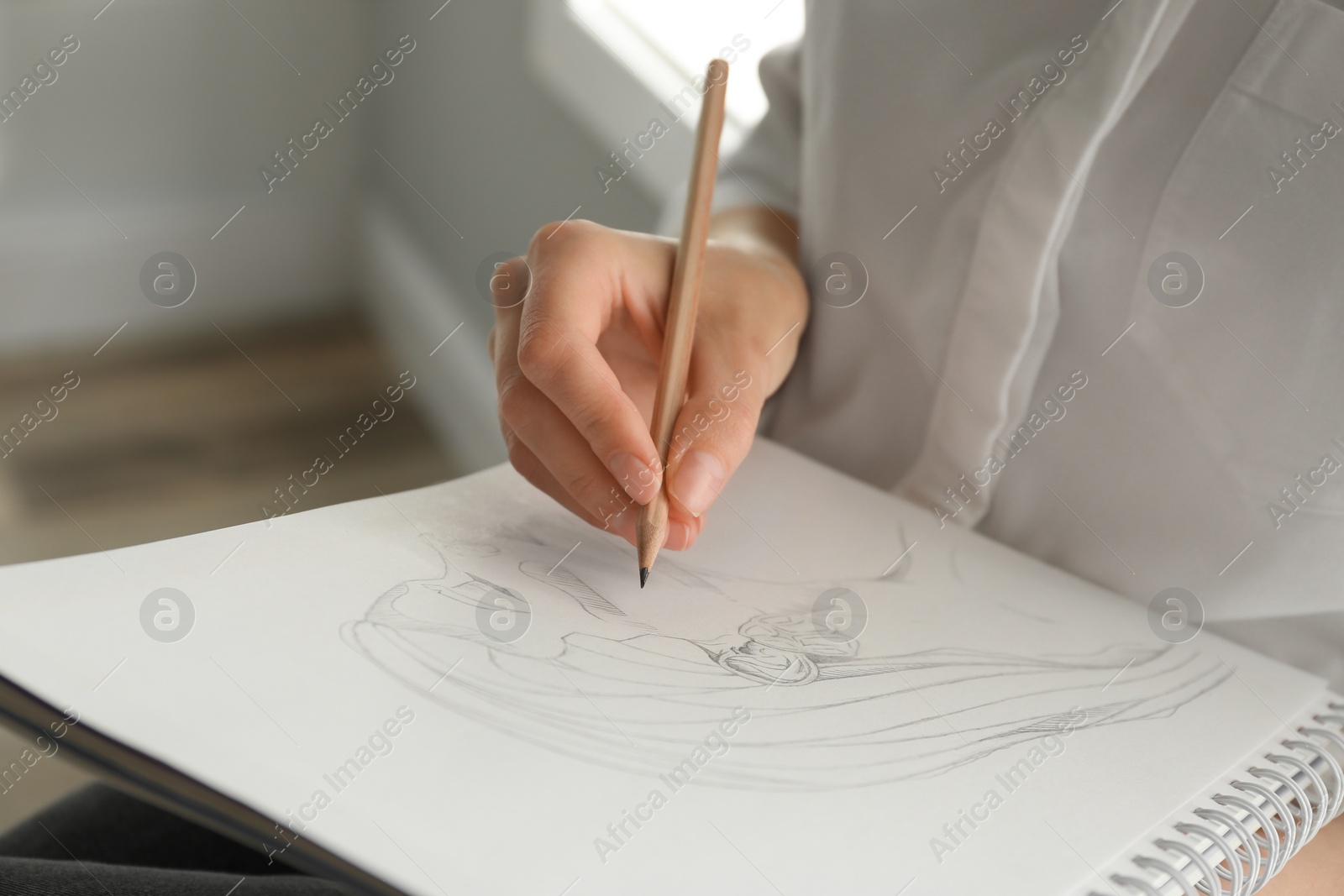 Photo of Woman drawing girl's portrait with pencil in notepad, closeup