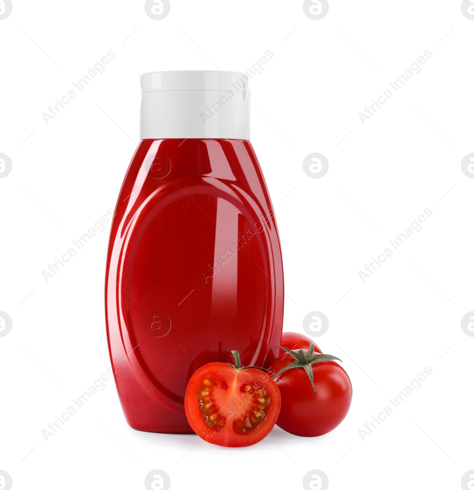 Photo of Bottle of tasty ketchup and fresh tomatoes isolated on white