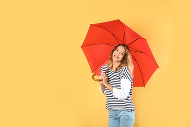 Woman with red umbrella on color background