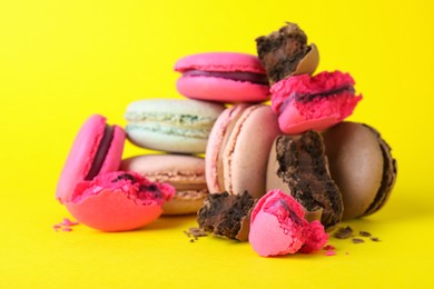 Photo of Pile of delicious colorful macarons on yellow background