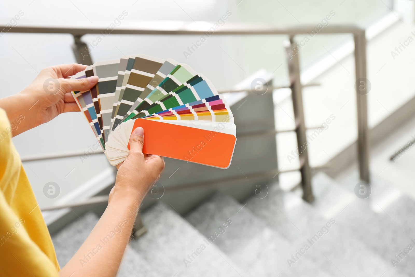 Photo of Female interior designer with color palette samples indoors, closeup. Space for text