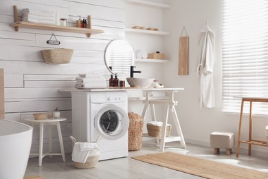 Photo of Stylish bathroom interior with modern washing machine