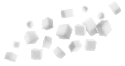 Image of Refined sugar cubes in air on white background