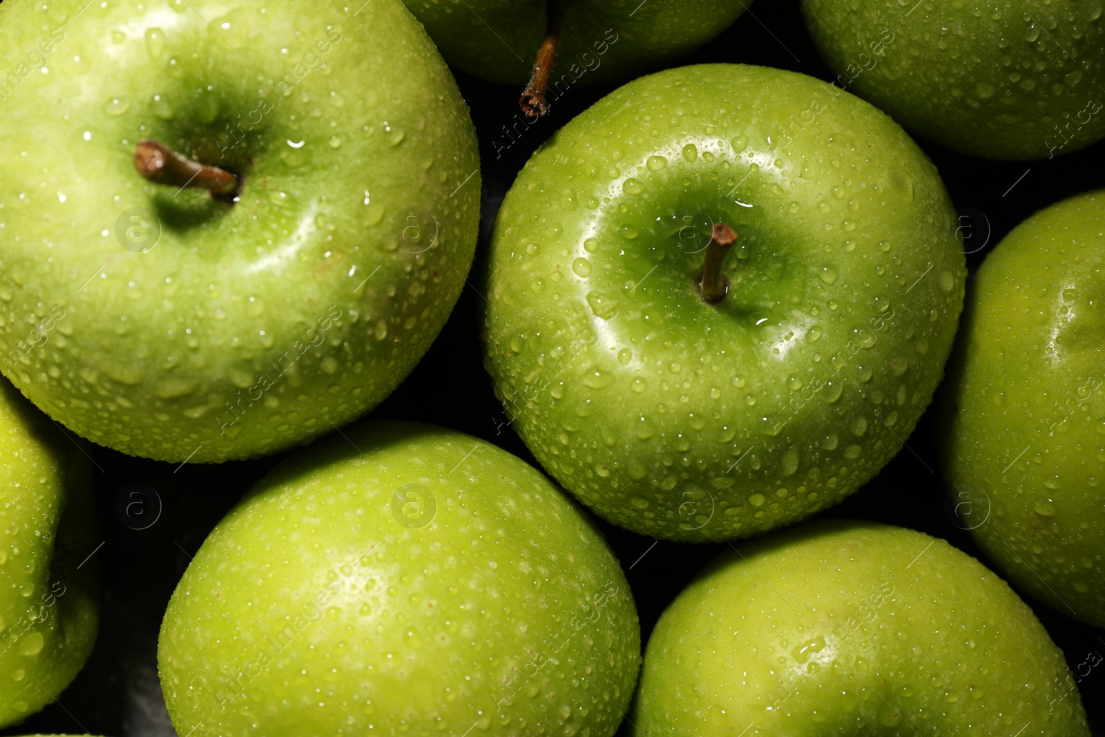 Photo of Ripe green apples with water drops as background, top view