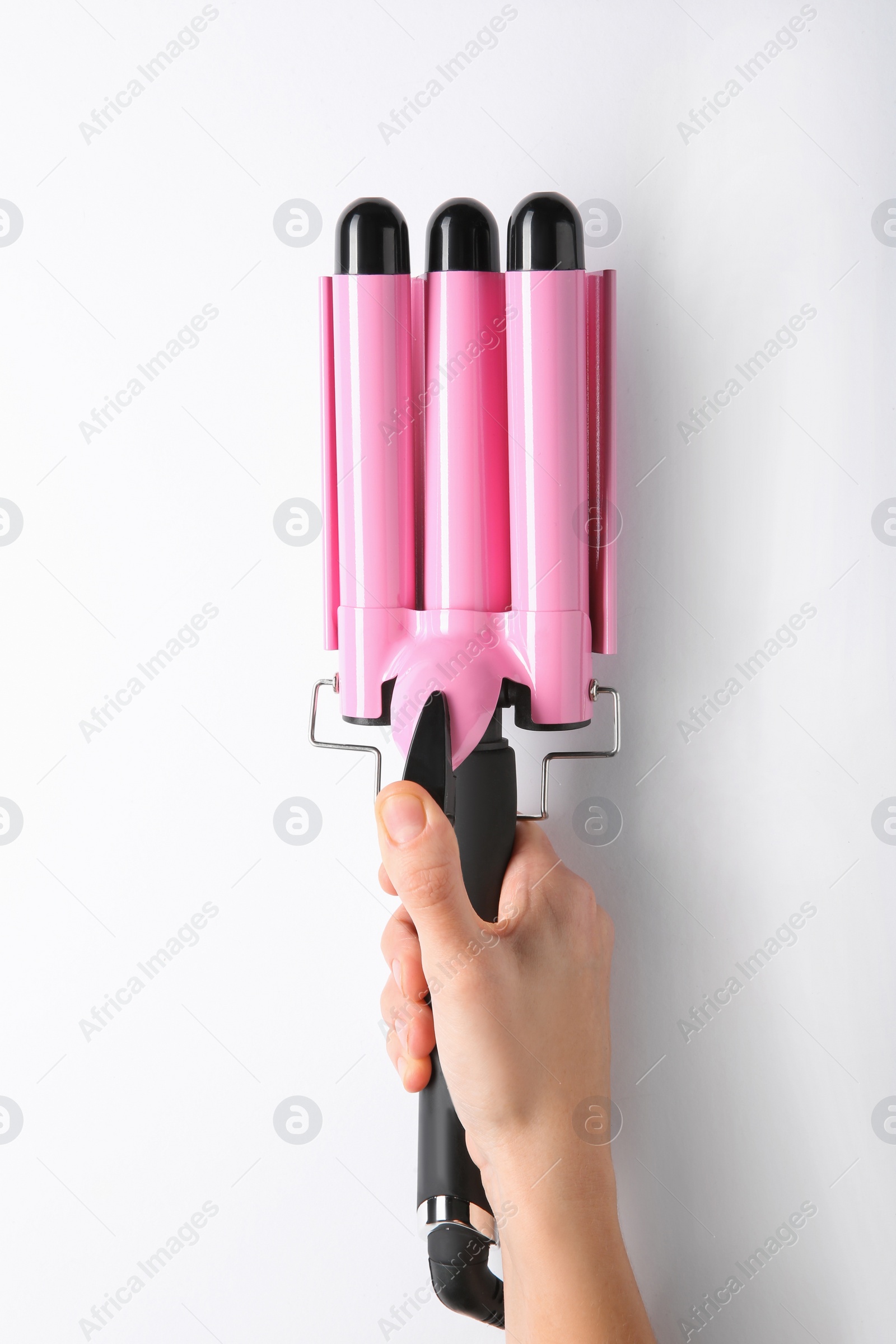 Photo of Woman holding triple curling hair iron on white background, closeup