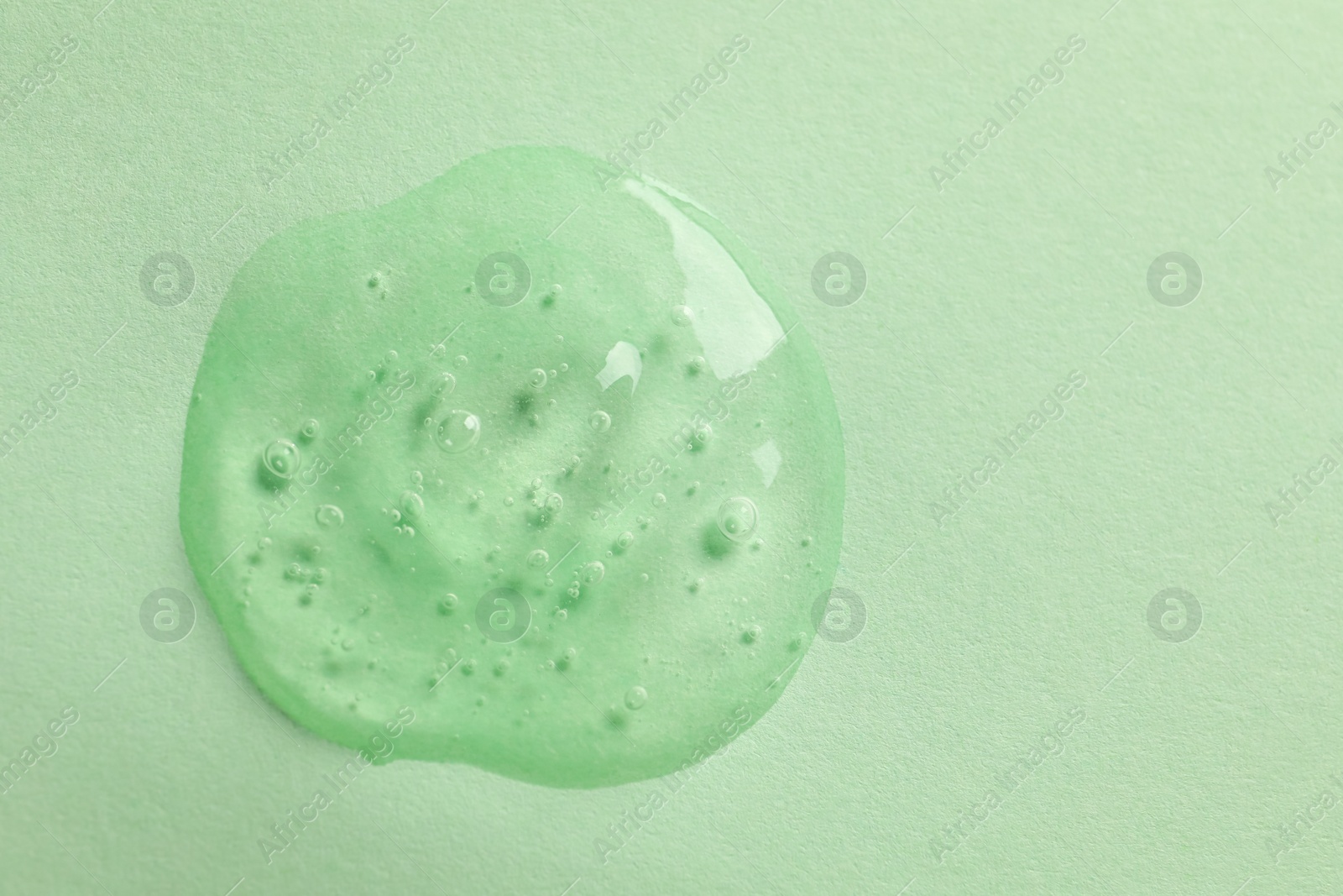 Photo of Sample of face gel on light green background, top view. Space for text