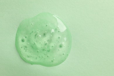 Photo of Sample of face gel on light green background, top view. Space for text