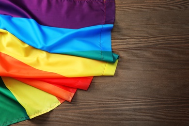 Rainbow gay flag on wooden background, top view with space for text. LGBT concept