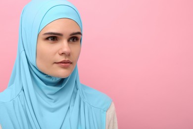 Photo of Portrait of Muslim woman in hijab on pink background, space for text