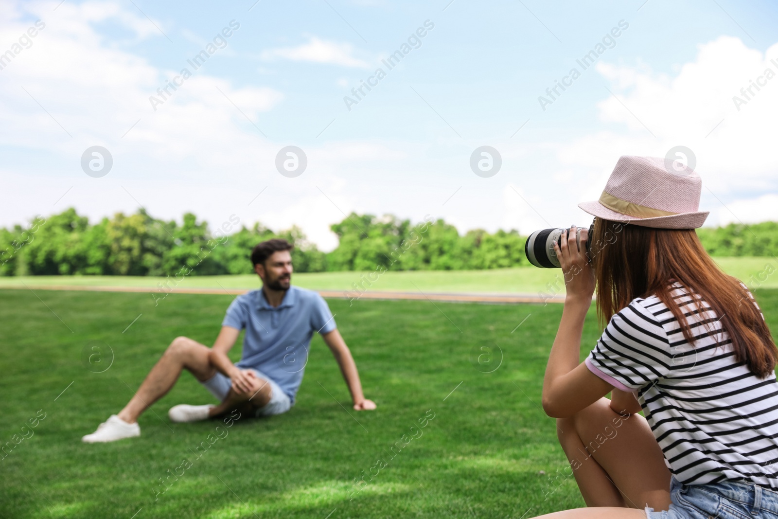Photo of Photographer taking photo of man with professional camera in park