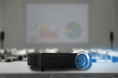 Image of Modern video projector and blurred conference room on background