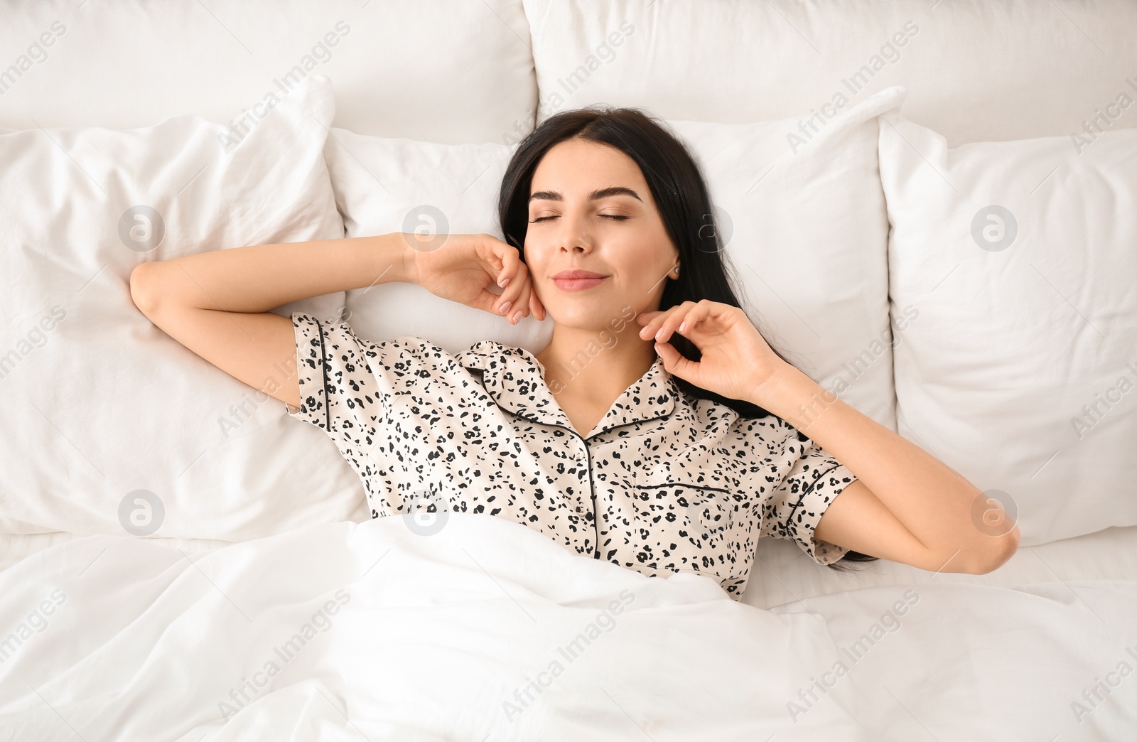 Photo of Young woman awakening at home, top view. Lazy morning