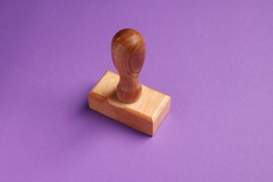 Photo of One wooden stamp tool on purple background