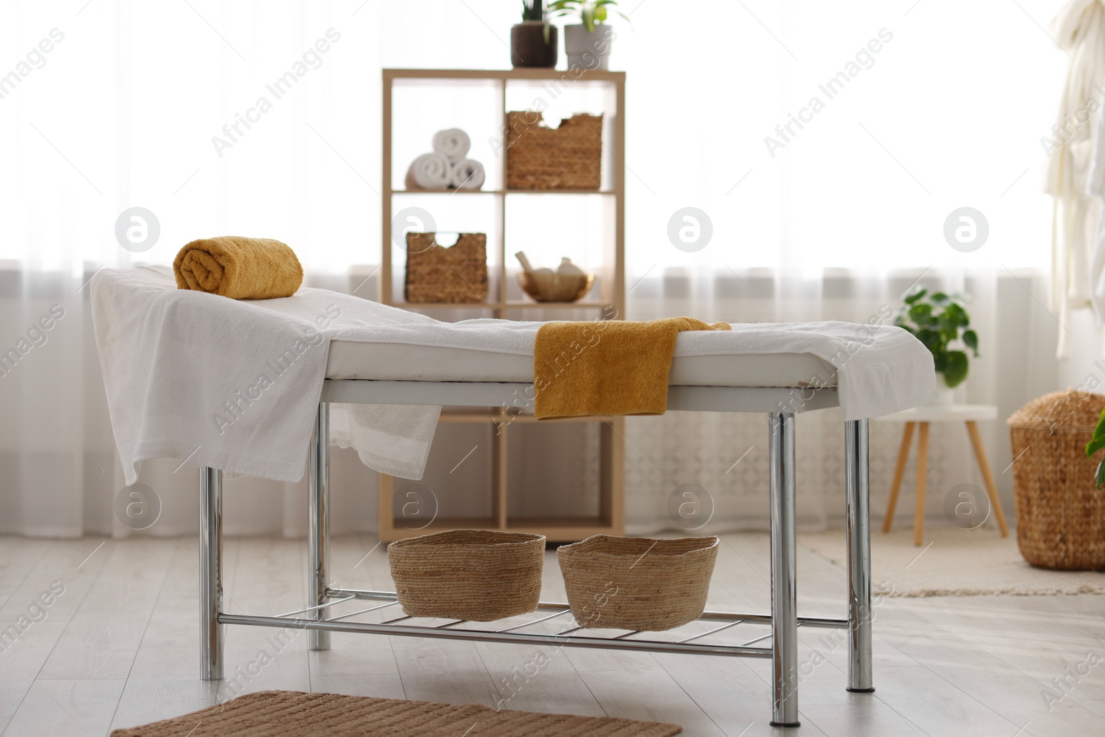 Photo of Comfortable massage table with clean towels in spa center