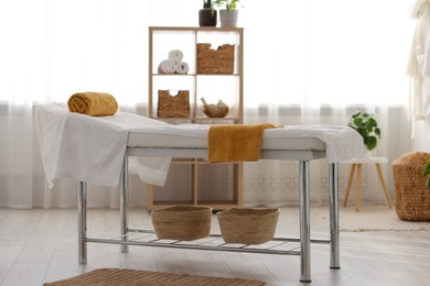 Comfortable massage table with clean towels in spa center