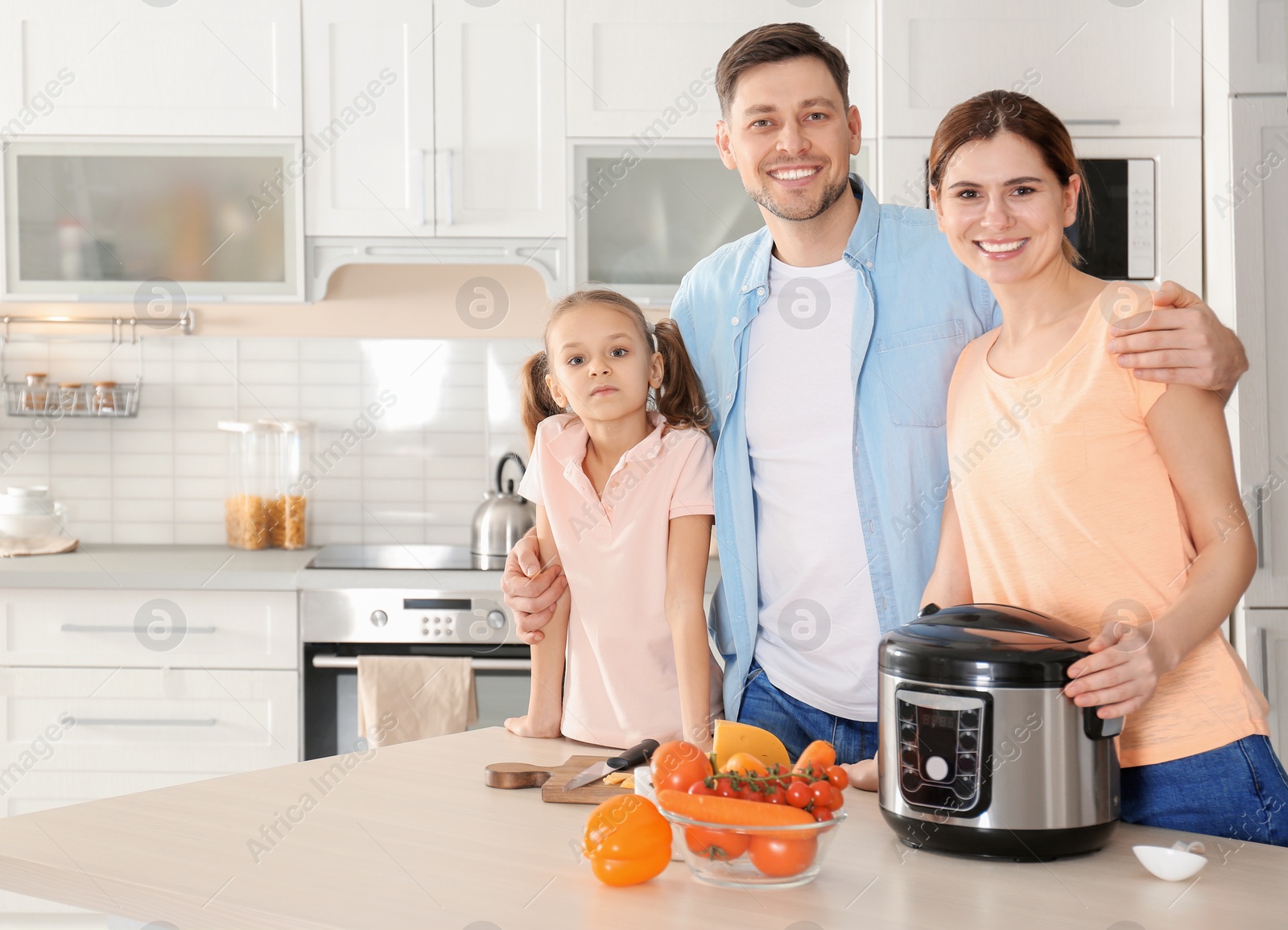 Photo of Happy family with modern multi cooker in kitchen