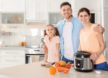 Photo of Happy family with modern multi cooker in kitchen