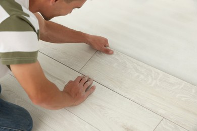 Professional worker installing new laminate flooring, closeup