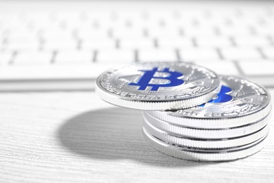 Photo of Silver bitcoins on wooden table, closeup. Space for text