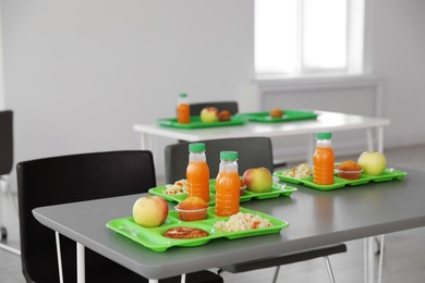 Trays with healthy food on table in school canteen