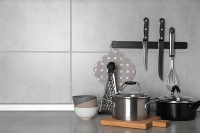 Cooking utensils and other kitchenware on grey countertop. Space for text