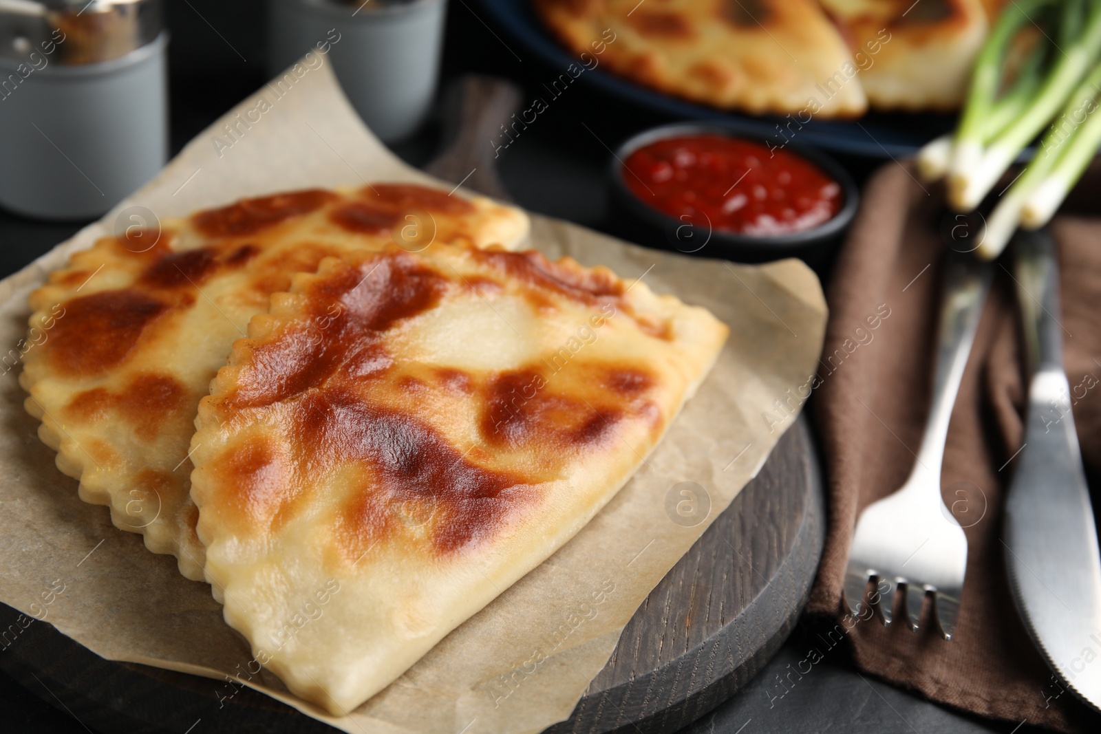 Photo of Delicious fried chebureki served on black table, closeup