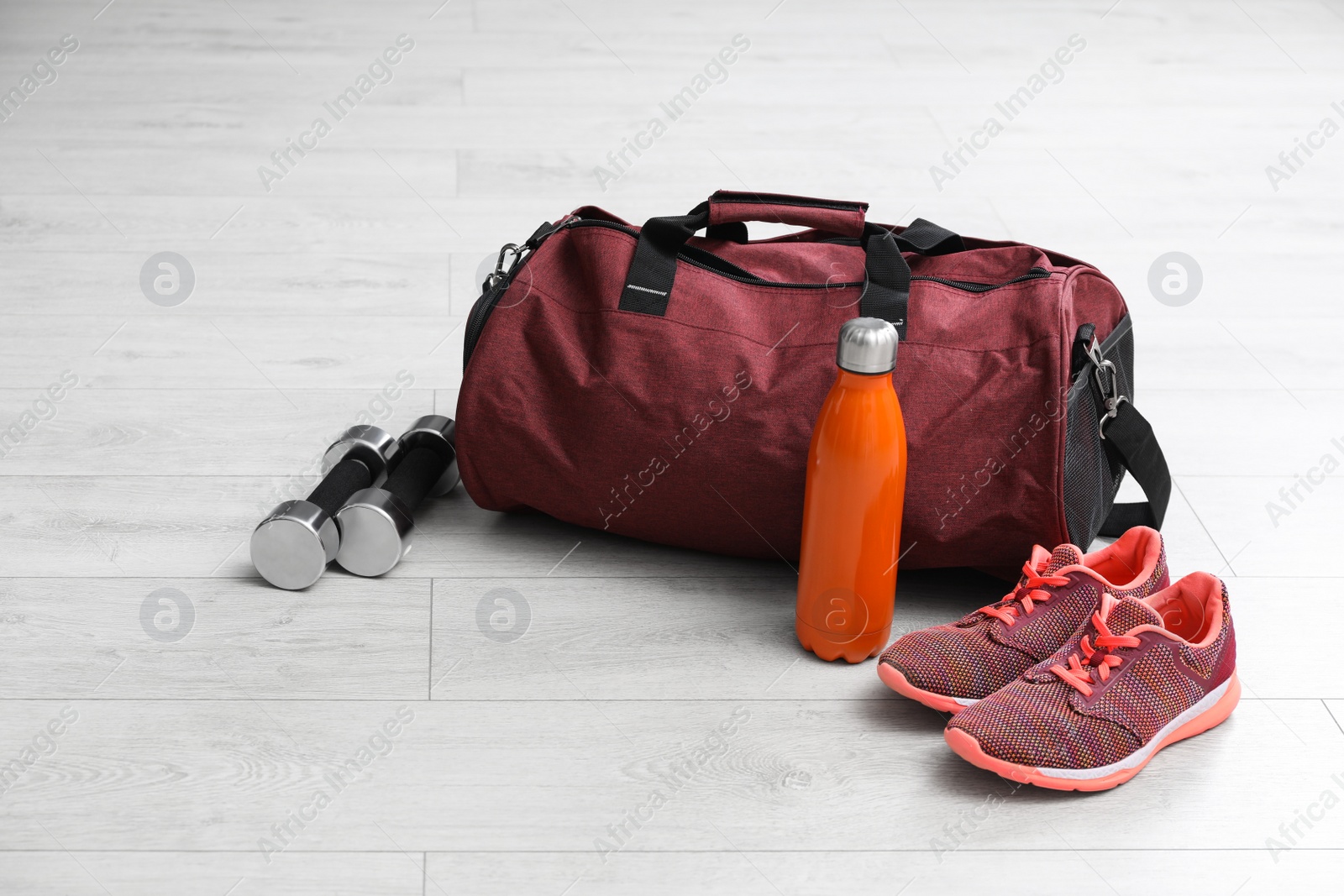 Photo of Sports bag and gym stuff on white floor
