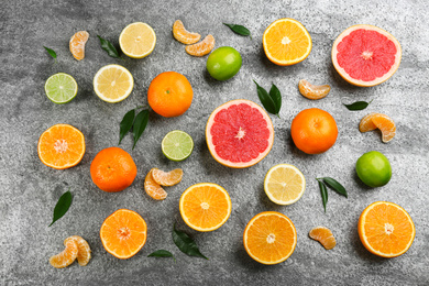 Photo of Flat lay composition with tangerines and different citrus fruits on grey background