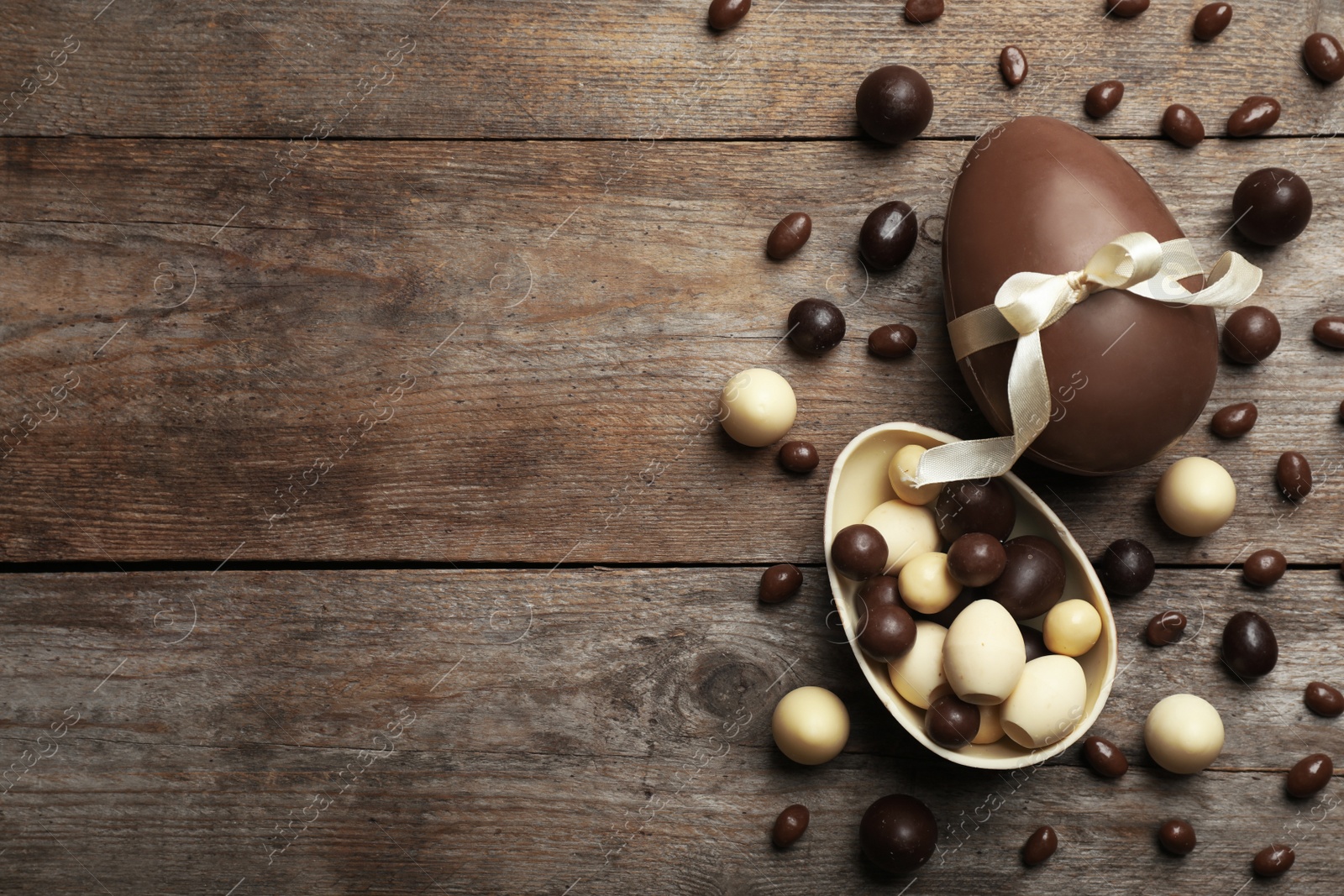 Photo of Flat lay composition with chocolate Easter eggs on wooden background, space for text