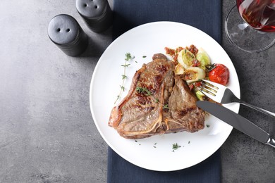 Photo of Delicious fried beef meat and vegetables served on grey table, flat lay. Space for text
