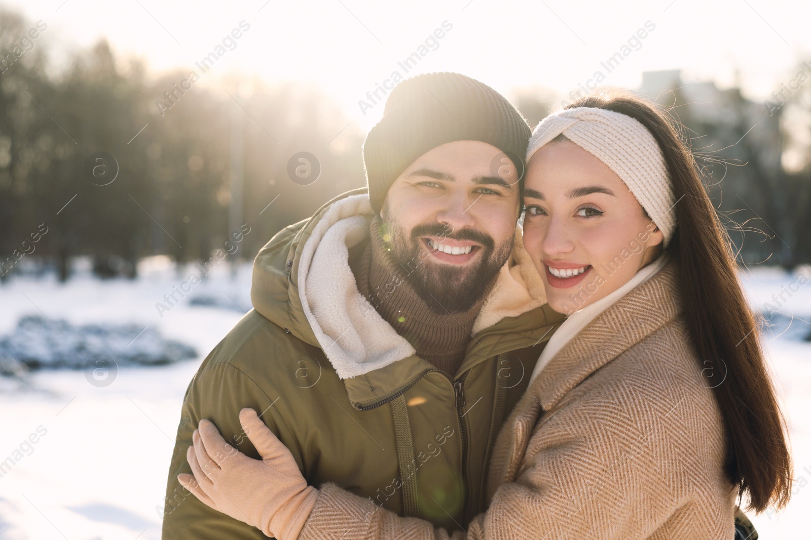 Photo of Beautiful happy couple in snowy park on winter day