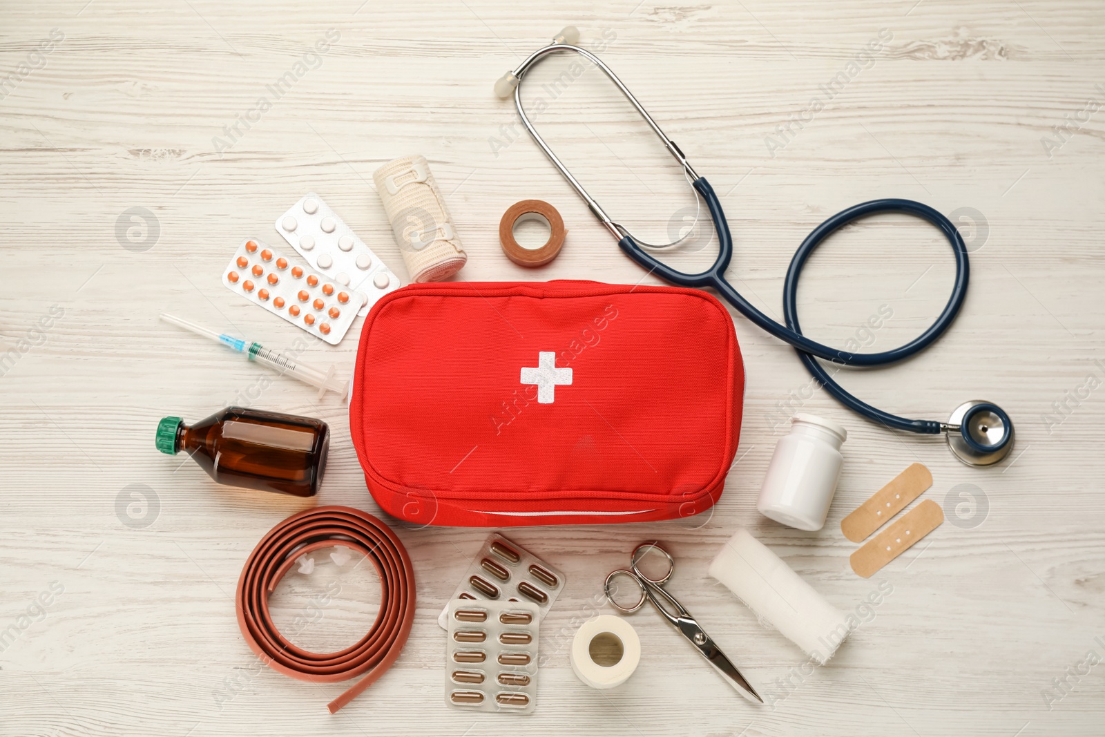 Photo of First aid kit on white wooden table, flat lay
