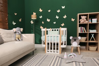 Photo of Beautiful baby room interior with stylish furniture and comfortable crib