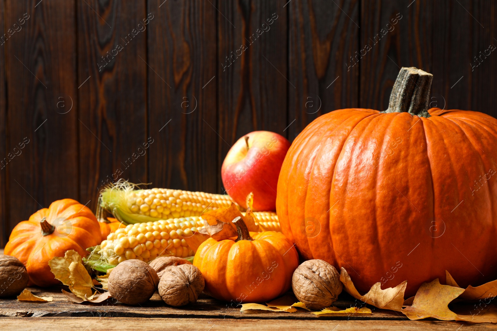 Photo of Composition with vegetables, nuts and autumn leaves on wooden table, space for text. Thanksgiving Day