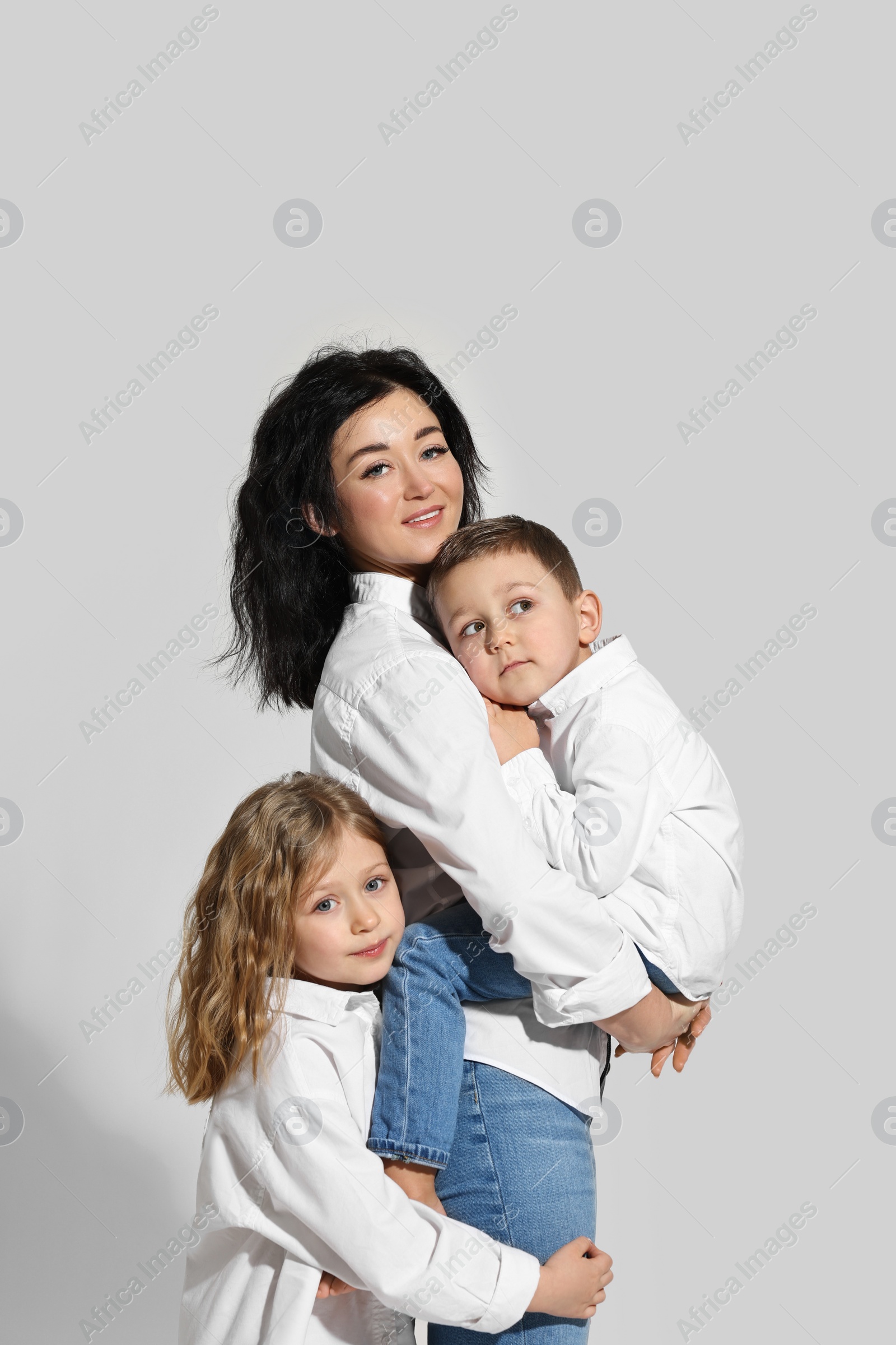 Photo of Little children with their mother on white background