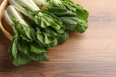 Photo of Fresh green pak choy cabbages on wooden table, space for text