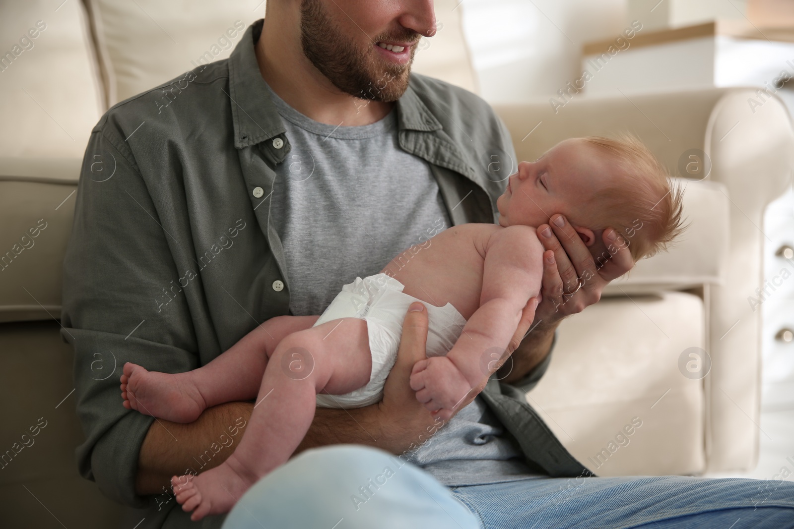 Photo of Father with his newborn son at home, closeup