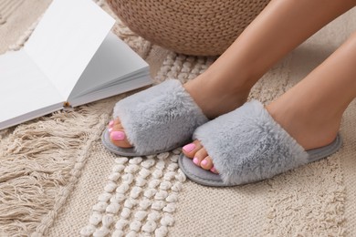 Photo of Woman wearing grey soft slippers indoors, closeup