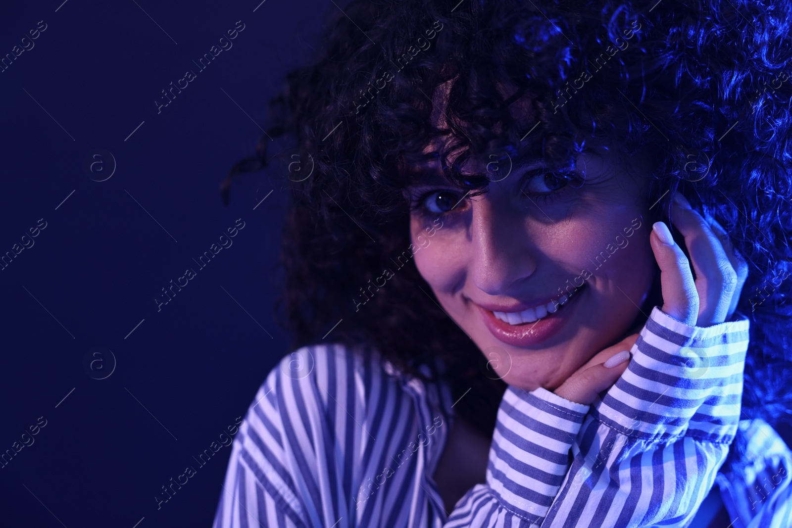 Photo of Beautiful young woman posing on color background in neon lights, closeup. Space for text